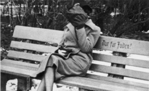 JA Jewish woman who is concealing her face sits on a park bench marked Only for Jews Austria 1938 450x275