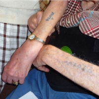 Paula and Klaus showing their numbered tattoos from Auschwitz.