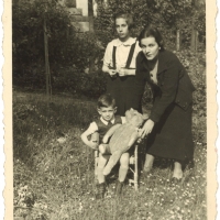 James is pictured here with a teddy bear, his mother, and his sister Marianne in his grandmother’s garden. 